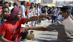 An Ethiopian worker argues with Saudi security forces while waiting for repatriation in Manfouha